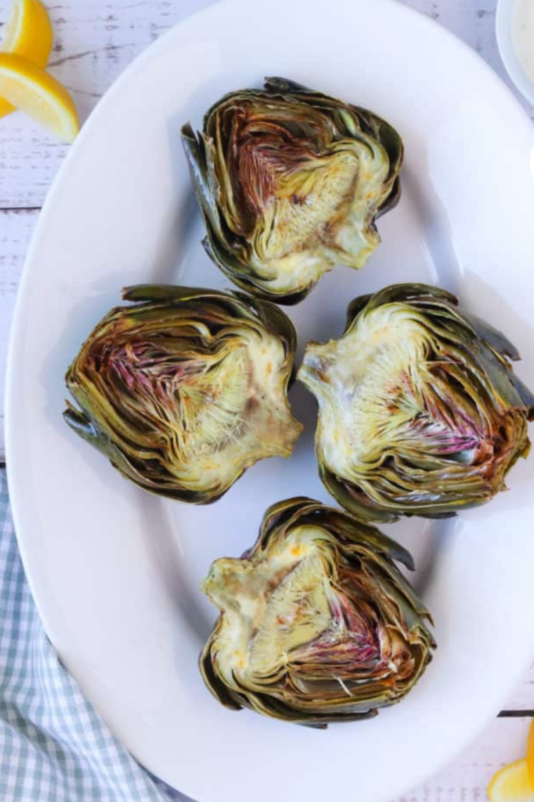 Air fryer roasted artichokes drizzled with lemon and olive oil."