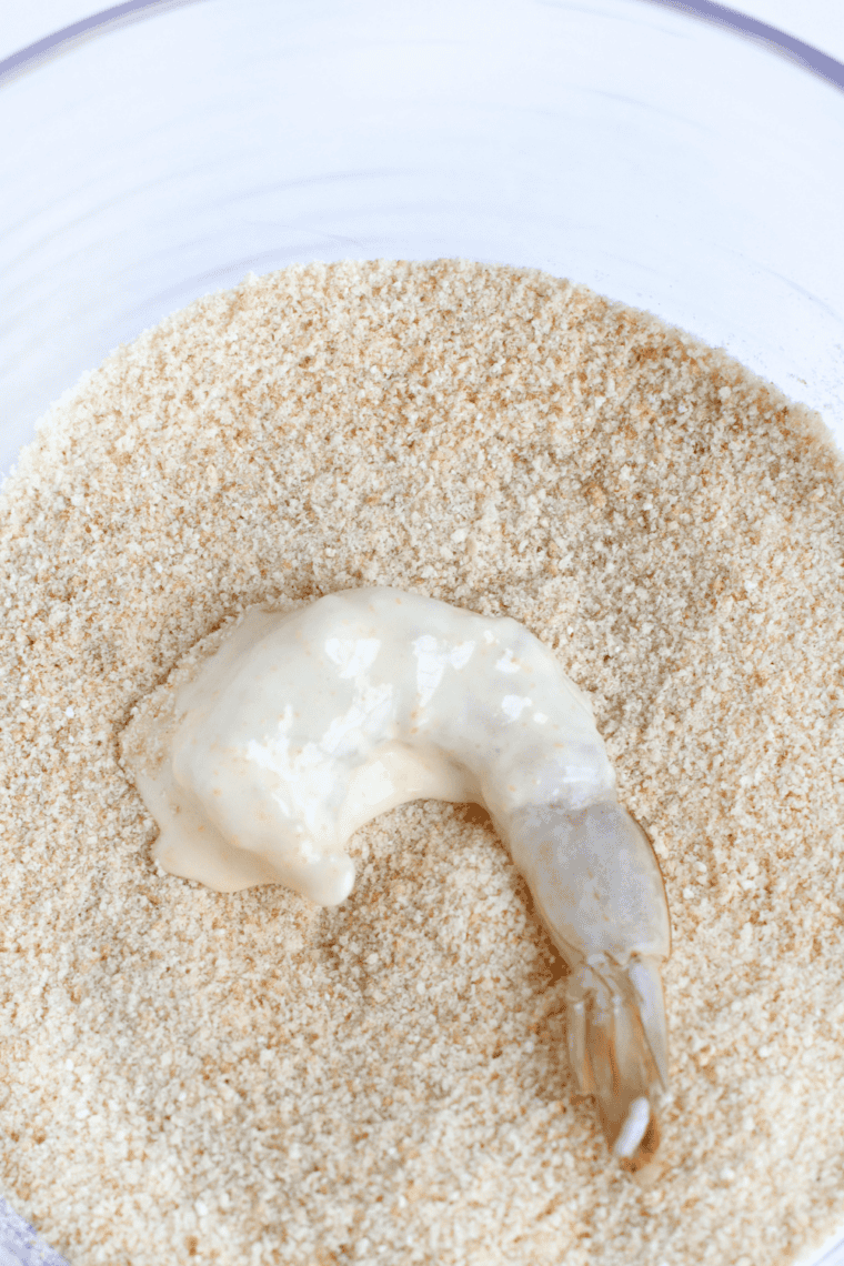 Shallow bowl with flour, cornstarch, paprika, garlic powder, onion powder, salt, black pepper, and cayenne being combined.