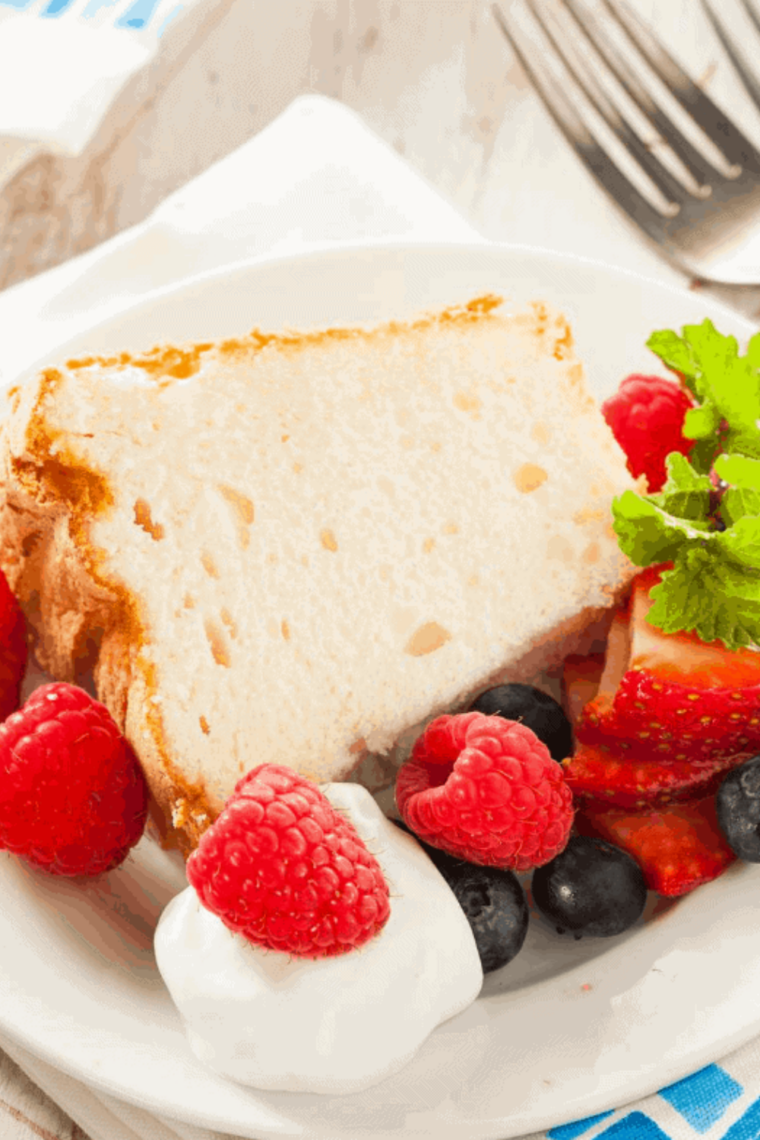 Golden, fluffy air fryer angel food cake sliced and ready to serve on a plate.