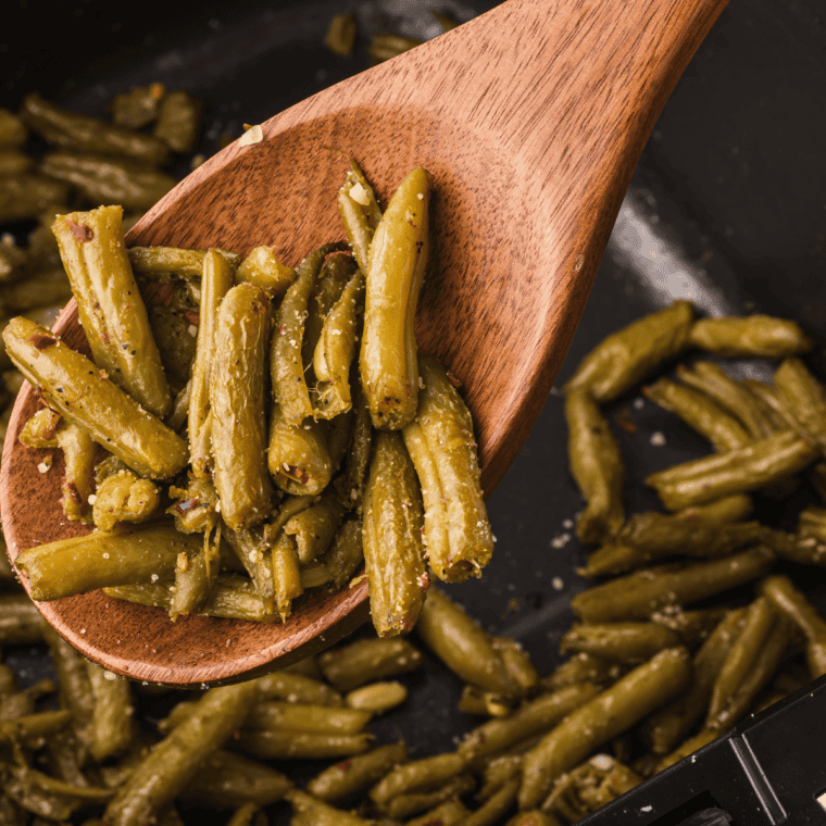 Air fryer canned green beans seasoned with garlic, pepper, and Parmesan, crispy and golden.