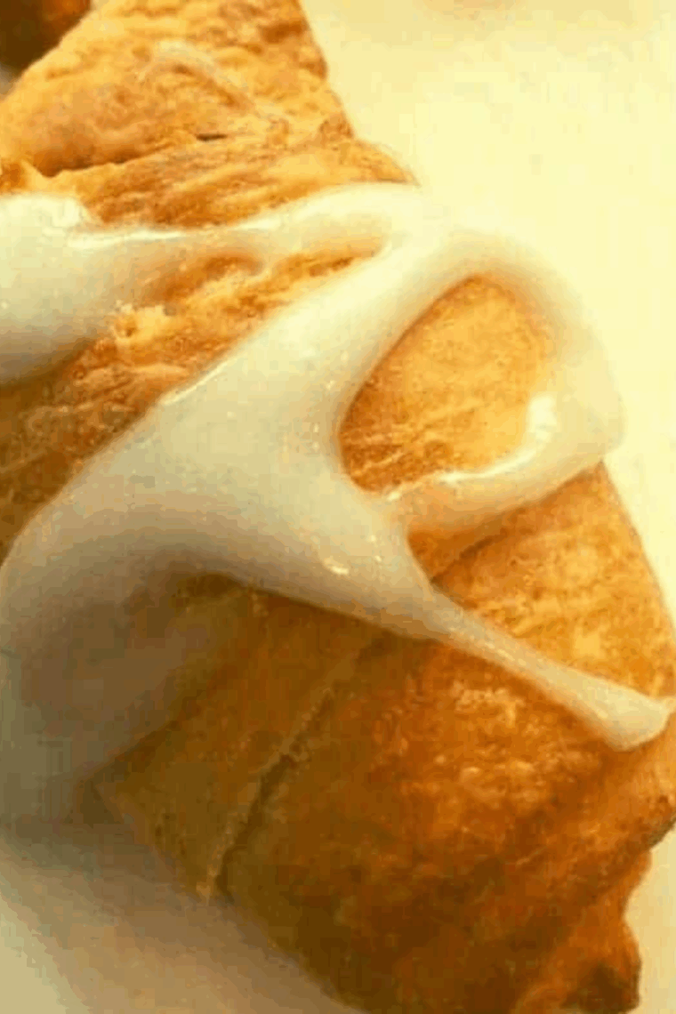 Golden-brown Air Fryer Caramel Apple Pie Crescents drizzled with sweet caramel and powdered sugar