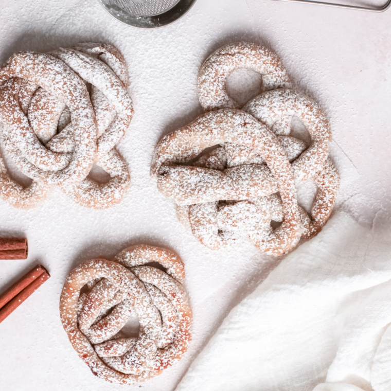 Air fryer basket filled with freshly cooked golden brown funnel cake swirls