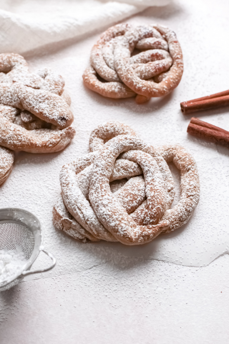 Homemade funnel cakes cooking inside an air fryer basket lined with parchment paper