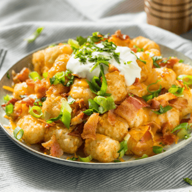 Loaded Air Fryer Tater Tots -- Get ready to elevate your snack game with our Loaded Air Fryer Tater Tots! Imagine your favorite crispy, golden tater tots coming hot out of the air fryer, then loaded with all the mouth-watering toppings that scream indulgence. We're talking melted cheese, crispy bacon bits, a sour cream dollop, and fresh green onions.