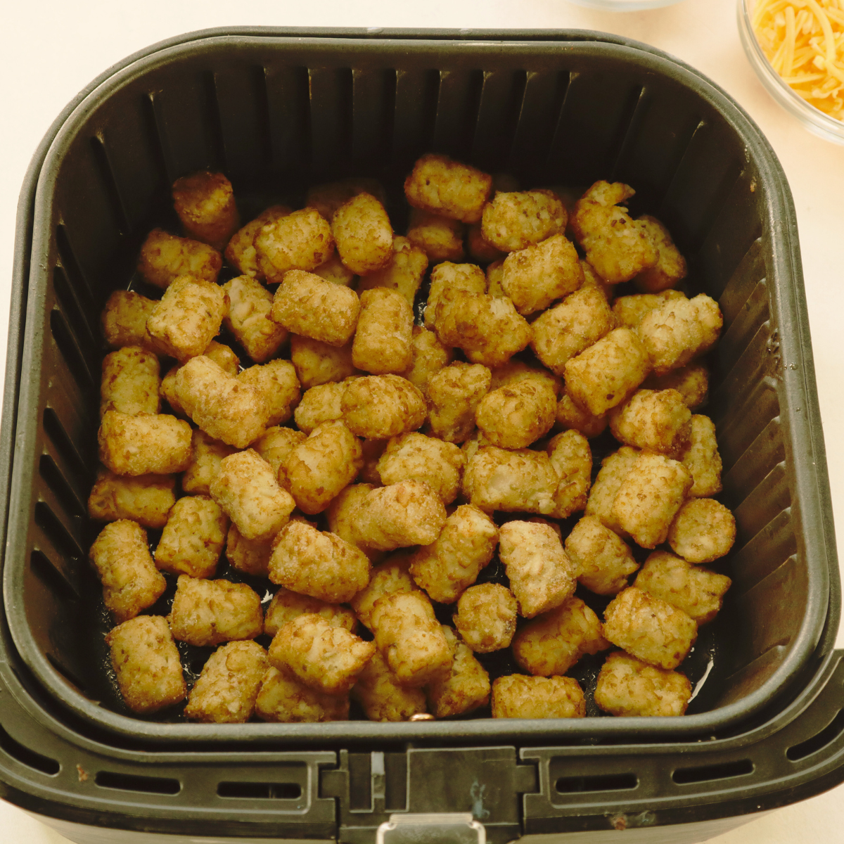 overhead: frozen tots cooking in basket for air fryer loaded tater tots