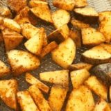 Golden air fryer potato cubes coated in glossy maple BBQ sauce, crispy outside, tender inside, served on a plate.