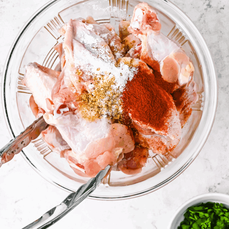 Seasonings the wings in a large mixing bowl.