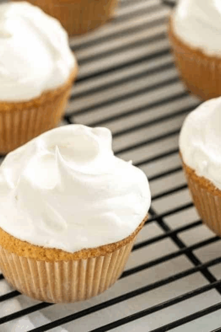Air fryer vanilla cupcakes in paper liners, golden and fluffy, served on a plate.