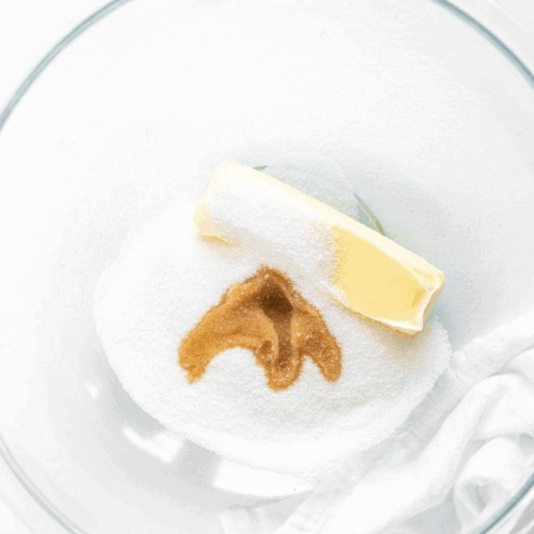 Creaming butter, granulated sugar, and vanilla in one bowl, while whisking flour, baking powder, and salt in another bowl.