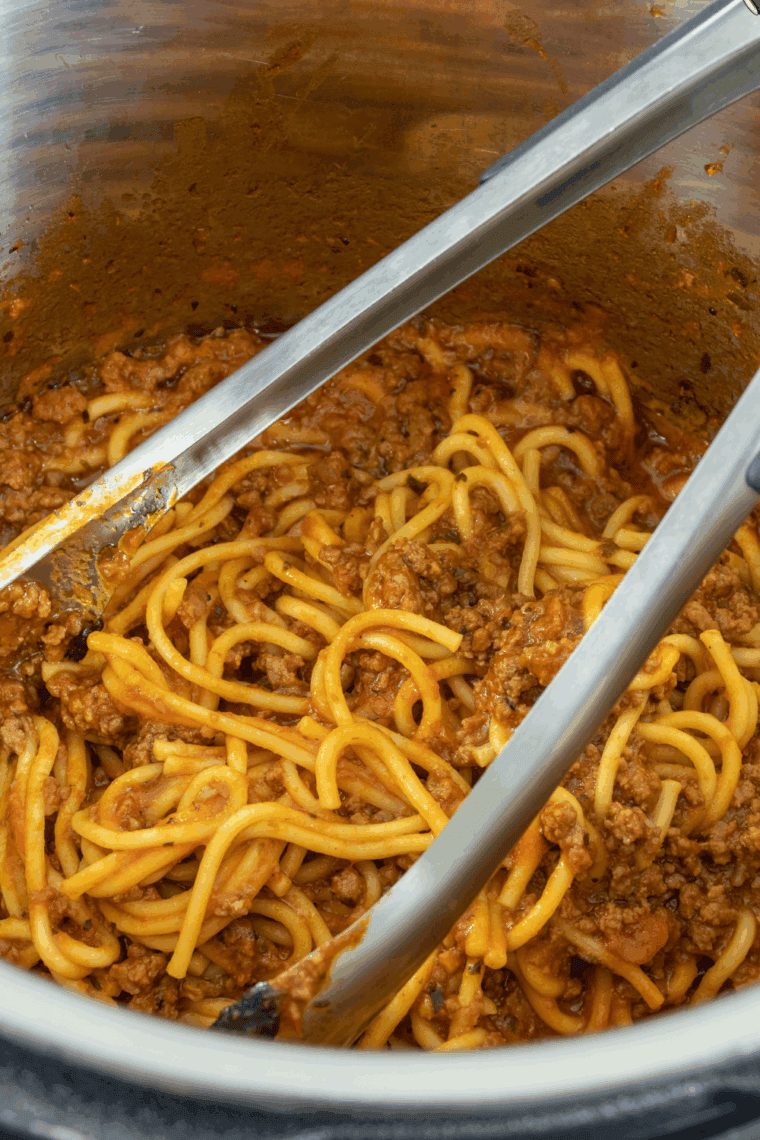 Plate of Carrabba's Spaghetti topped with savory meat sauce and garnished with fresh herbs.