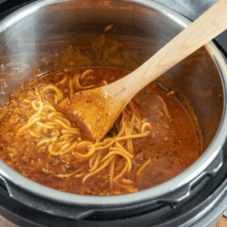Bowl of Carrabba’s Spaghetti Recipe with wooden spoon.