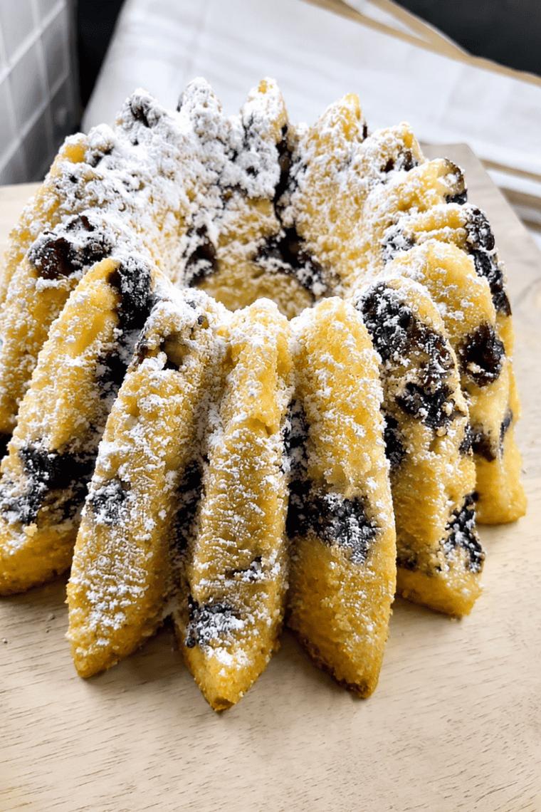 Copycat Nothing Bundt Cakes lemon blueberry bundt cake dusted with powdered sugar on a white cake stand