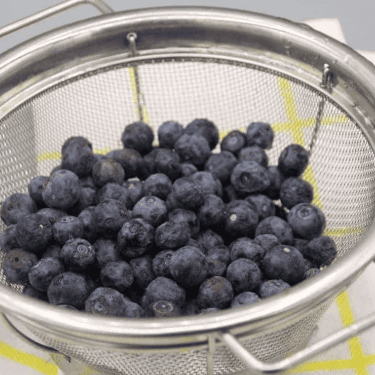 Wild blueberries tossed with flour in a small bowl to keep them from sinking in the batter