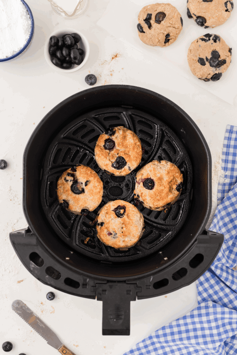 Freshly baked air fryer blueberry biscuits, golden and fluffy, arranged on a plate, ready to serve.
