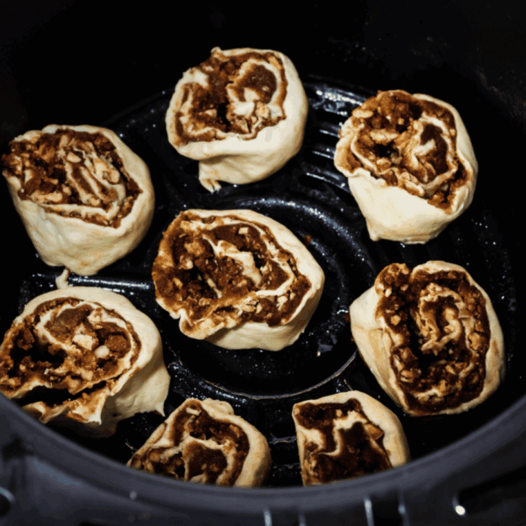 Golden air fryer cinnamon rolls made from frozen bread dough with glaze.