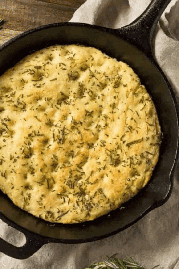 Air fryer garlic herb quick bread, golden crust, sliced and garnished with fresh herbs