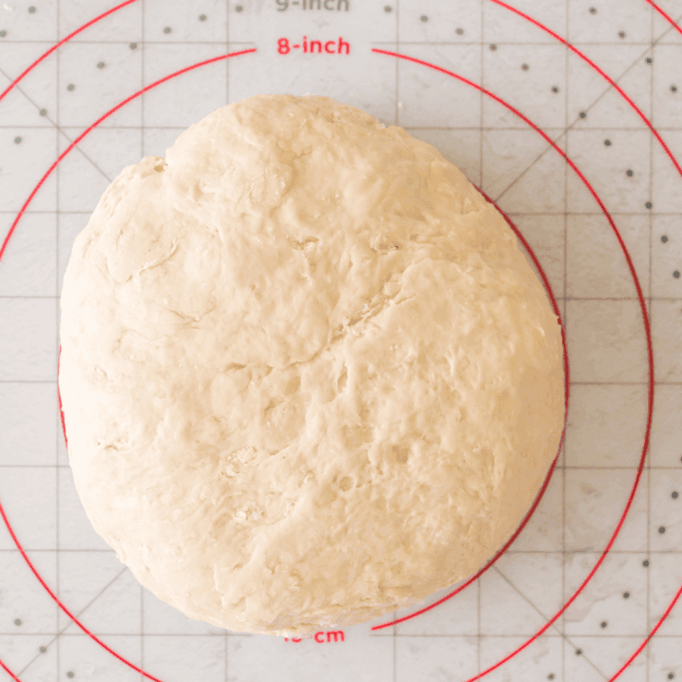Knead the Dough: Smooth, elastic dough being kneaded on floured surface.