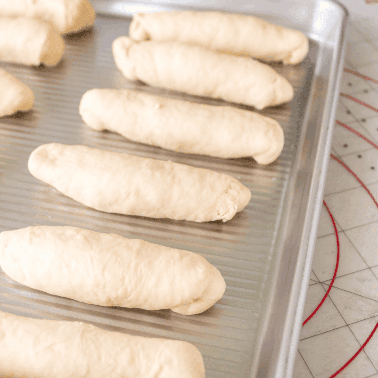 Second Rise: Breadsticks rising under a towel before baking.
