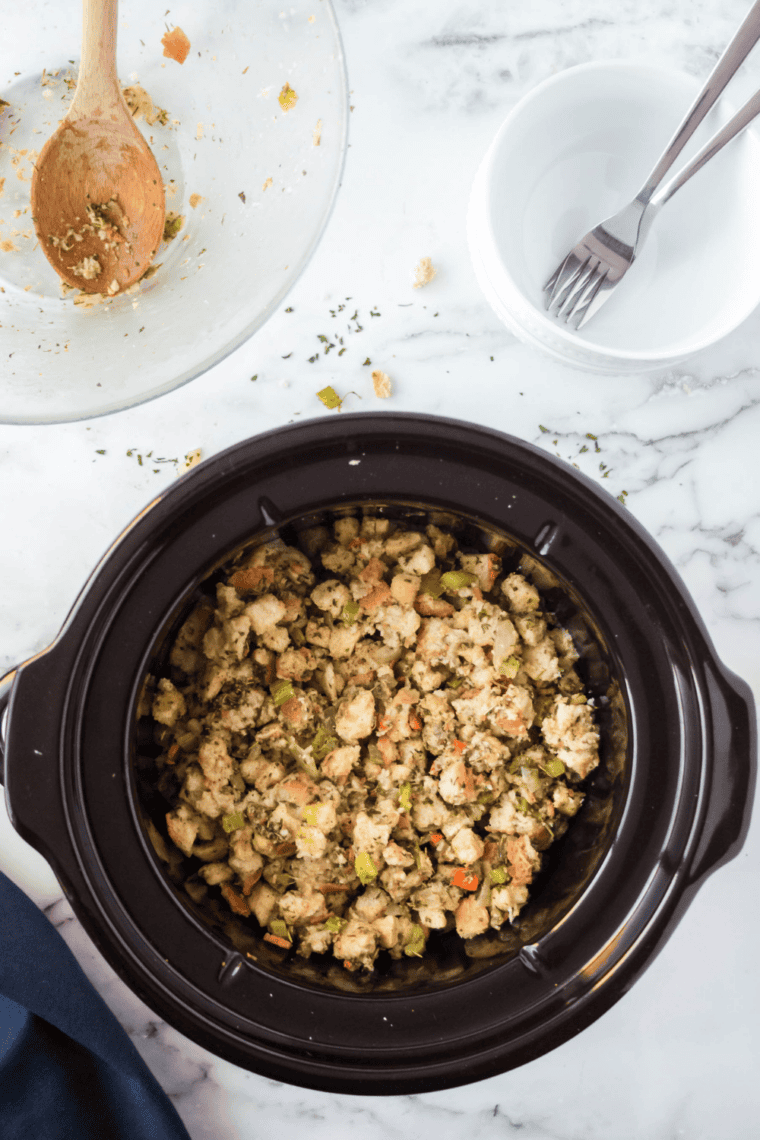 Fluffing the finished crockpot stovetop stuffing with a fork before serving