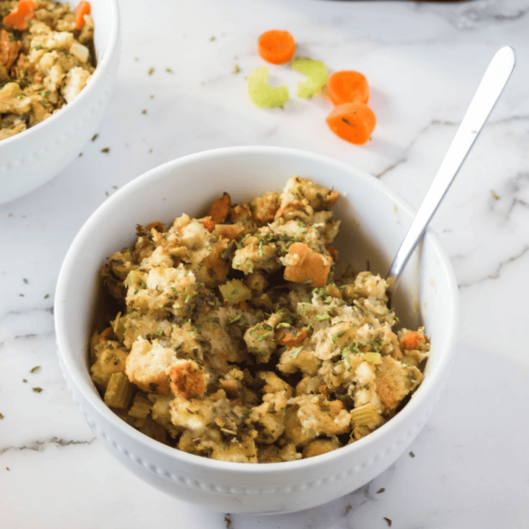 Plate of stovetop stuffing made in the crockpot garnished with fresh herbs