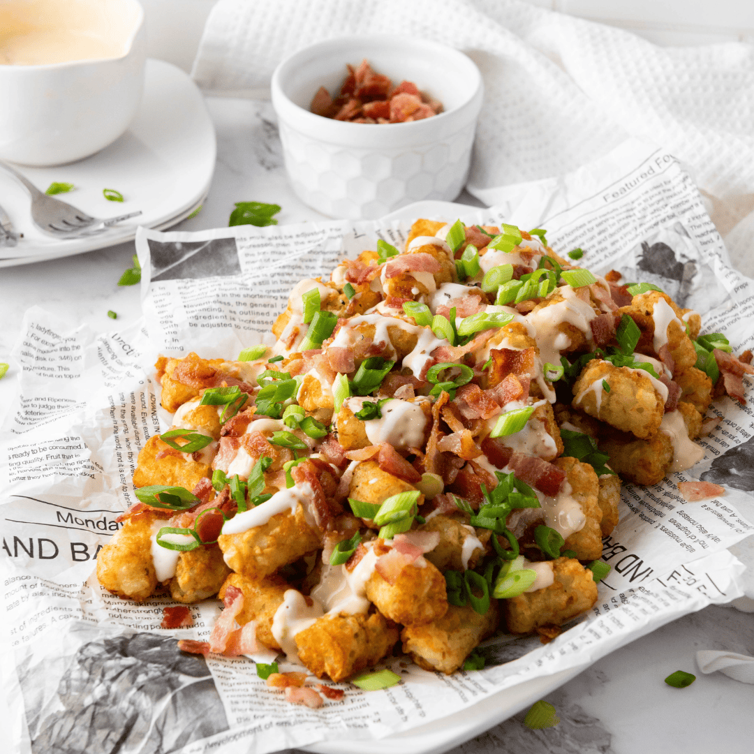 my loaded tater tot recipe with lots of toppings on a piece of newspaper