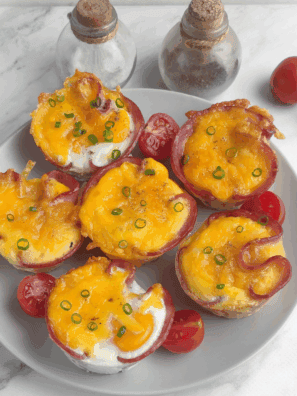 Air fryer ham and egg cups baked in a muffin-style shape with melted cheese on top