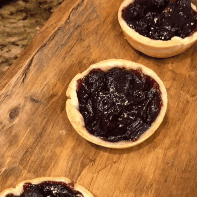 Golden air fryer jam tarts filled with blueberry jam, cooling on a wire rack.