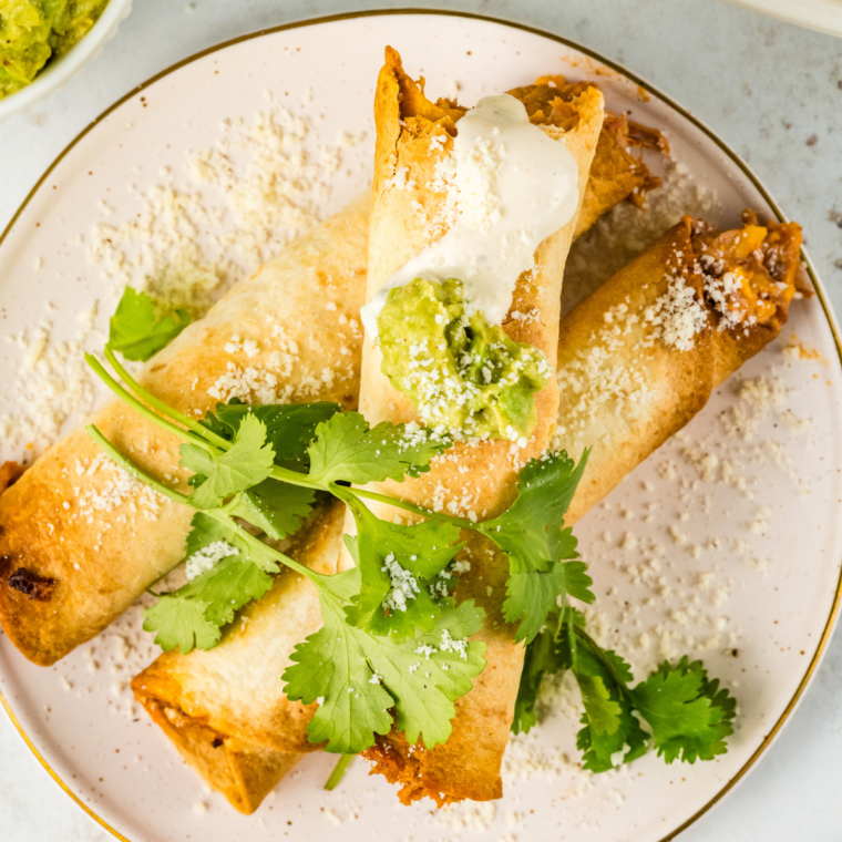 Crispy air fryer beef and bean taquitos filled with seasoned beef, refried beans, and melted cheese served with dipping sauce