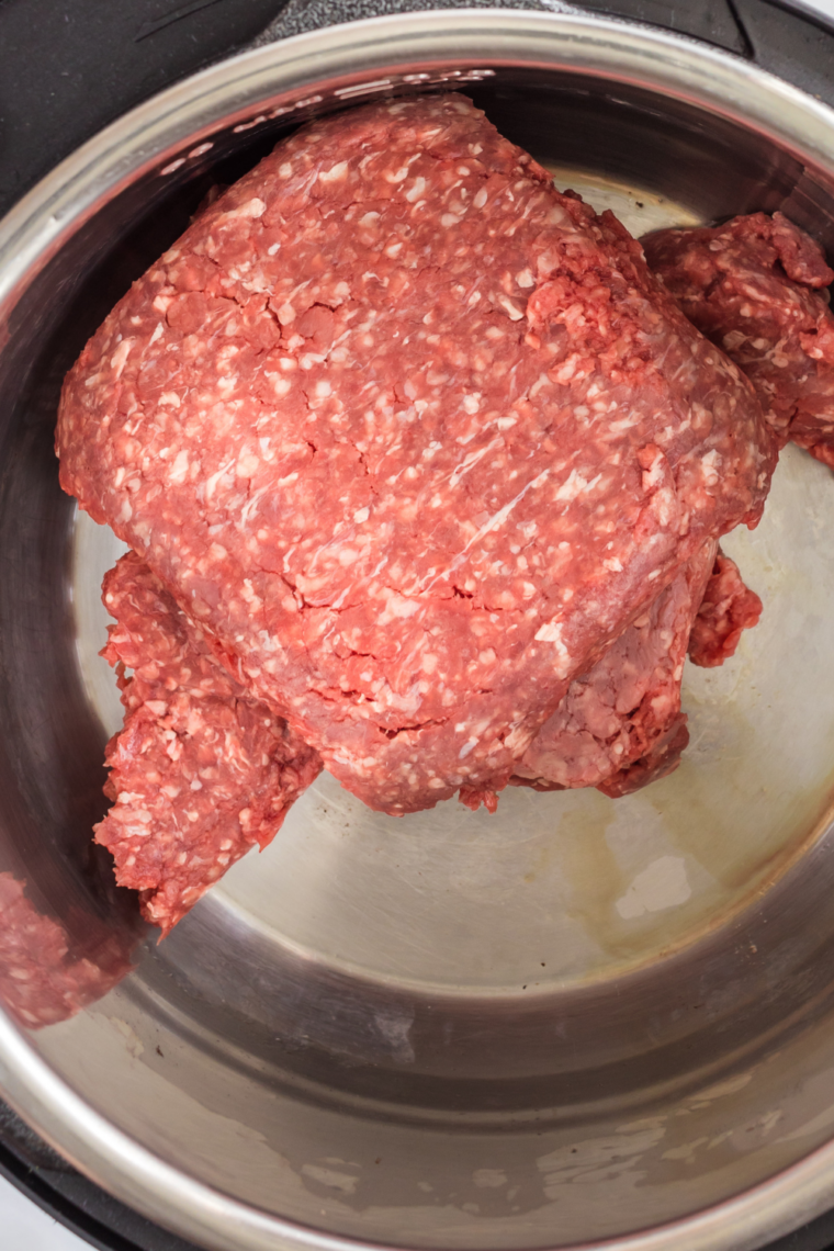 Browning ground beef in skillet with taco seasoning until fully cooked and coated