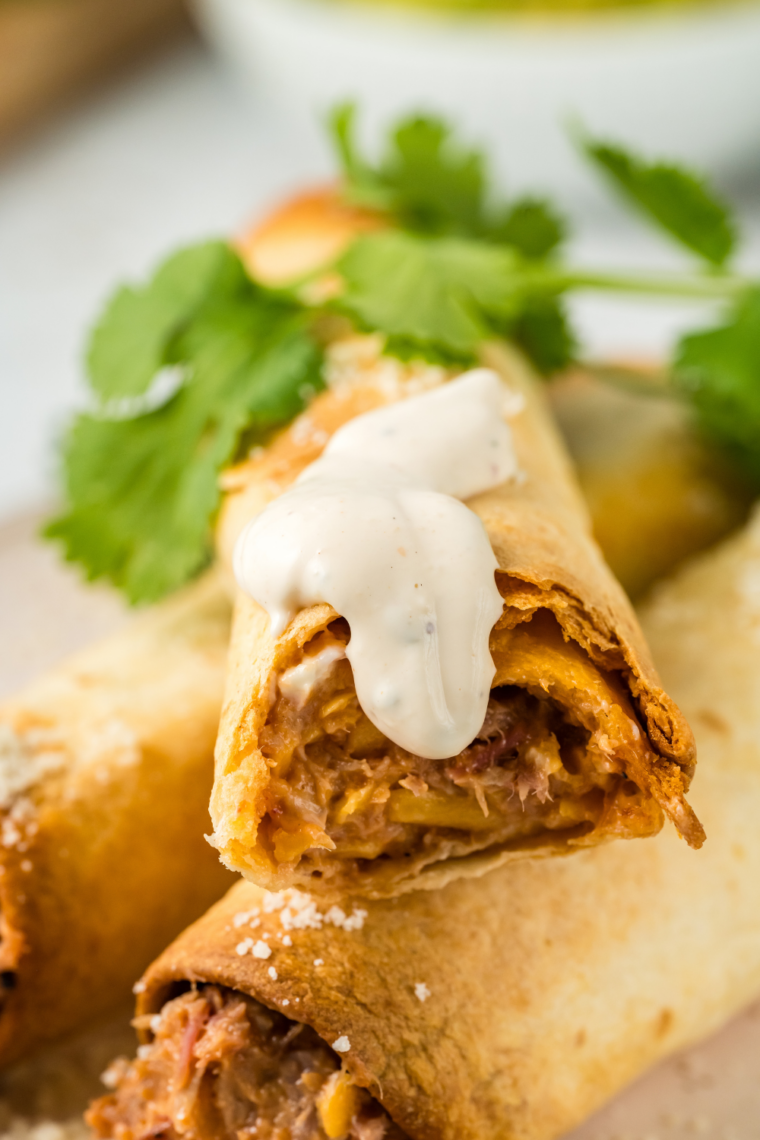 Crispy air fryer beef and bean taquitos filled with seasoned beef, refried beans, and melted cheese served with dipping sauce and toppings