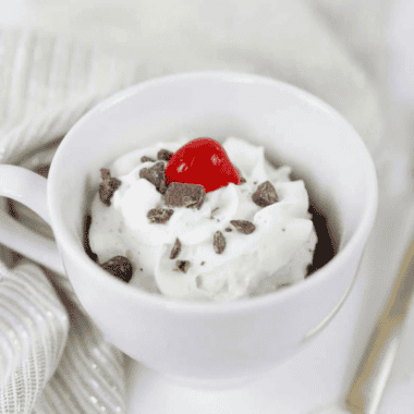 Warm fudgy brownie in a mug cooked in air fryer, rich chocolate single-serve dessert with gooey center served for quick treat or snack