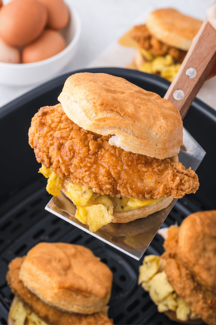 Golden homemade buttermilk biscuits baked in an air fryer basket with flaky layers and soft fluffy centers.