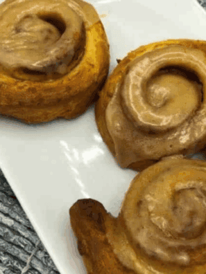 Pumpkin cinnamon rolls made in the air fryer with creamy glaze.