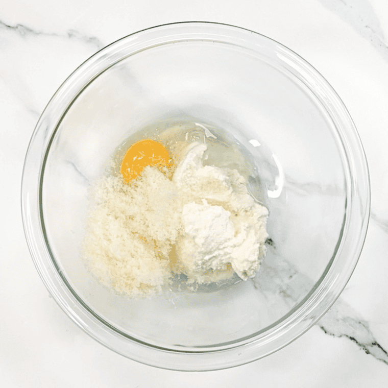 Mixing ricotta, egg, and Parmesan cheese; layering meat sauce and ricotta mixture in bell peppers.