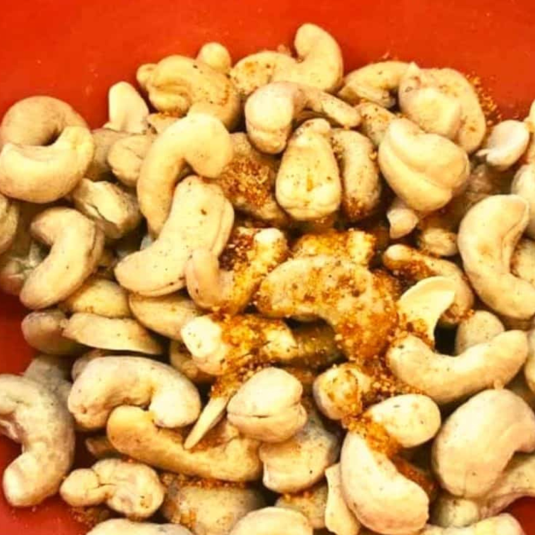 mage of cashews being tossed with olive oil: "Tossing raw cashews in olive oil"