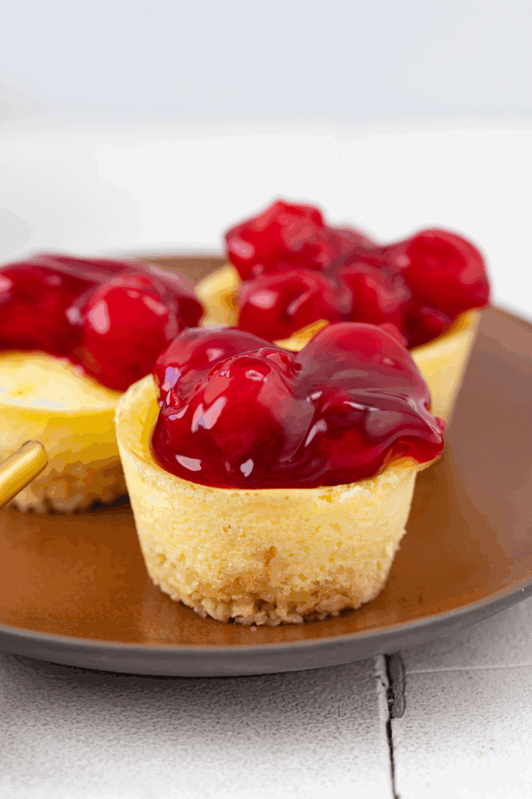 Air fryer mini cheesecakes with golden crust and creamy filling, topped with fresh fruit.