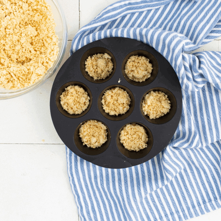 Crushed vanilla wafer crumbs pressed into muffin tin cups.