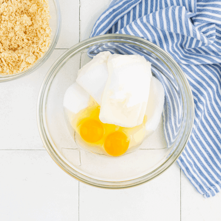 Cheesecake batter spooned over wafer crust in muffin tin.