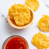 Crispy golden Parmesan crisps fresh from the air fryer on a plate.