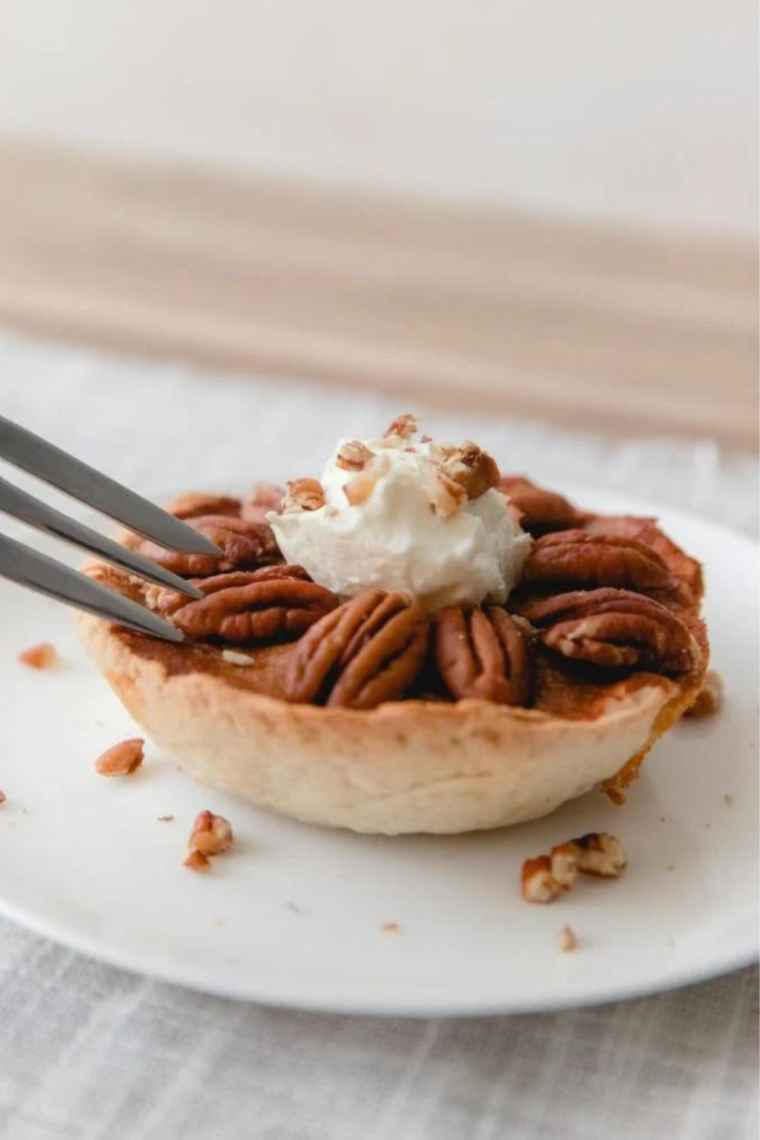 "Close-up of a freshly baked Air Fryer Pecan Pie topped with pecans"