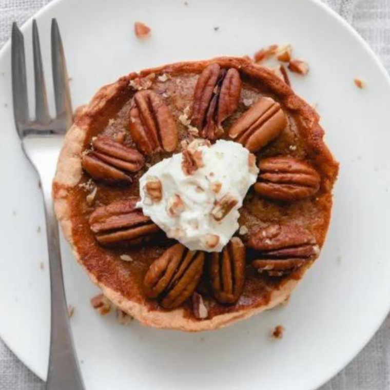 Serving suggestion for Air Fryer Pecan Pie with whipped cream and pecans