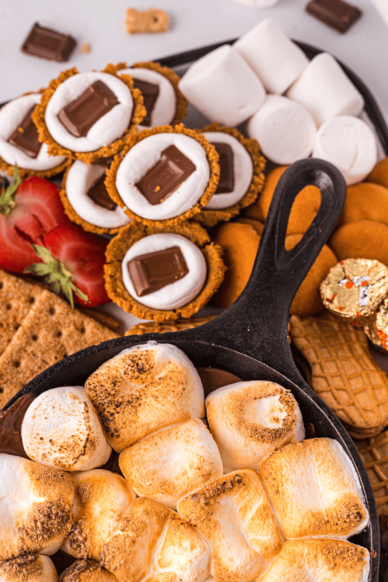 Air fryer s&rsquo;mores cookie cups with melted chocolate and golden toasted marshmallows on top.