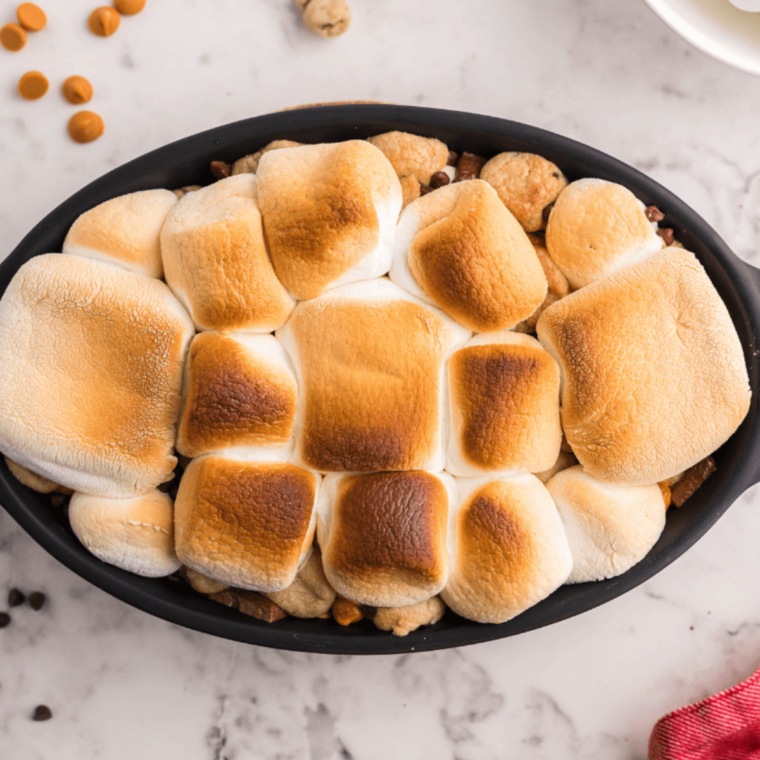 Close-up of gooey Air Fryer S'mores Dip with toasted marshmallows on top.