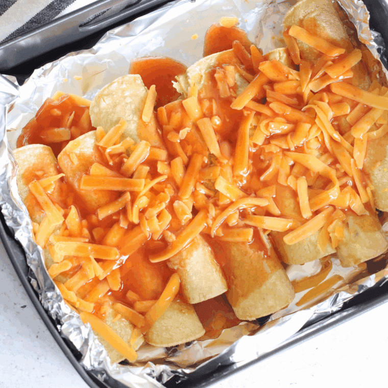 Finished enchiladas topped with Rotel, onions, jalapeños, and fresh toppings.