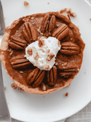 Air fryer pecan pie on a dessert plate with one slice removed