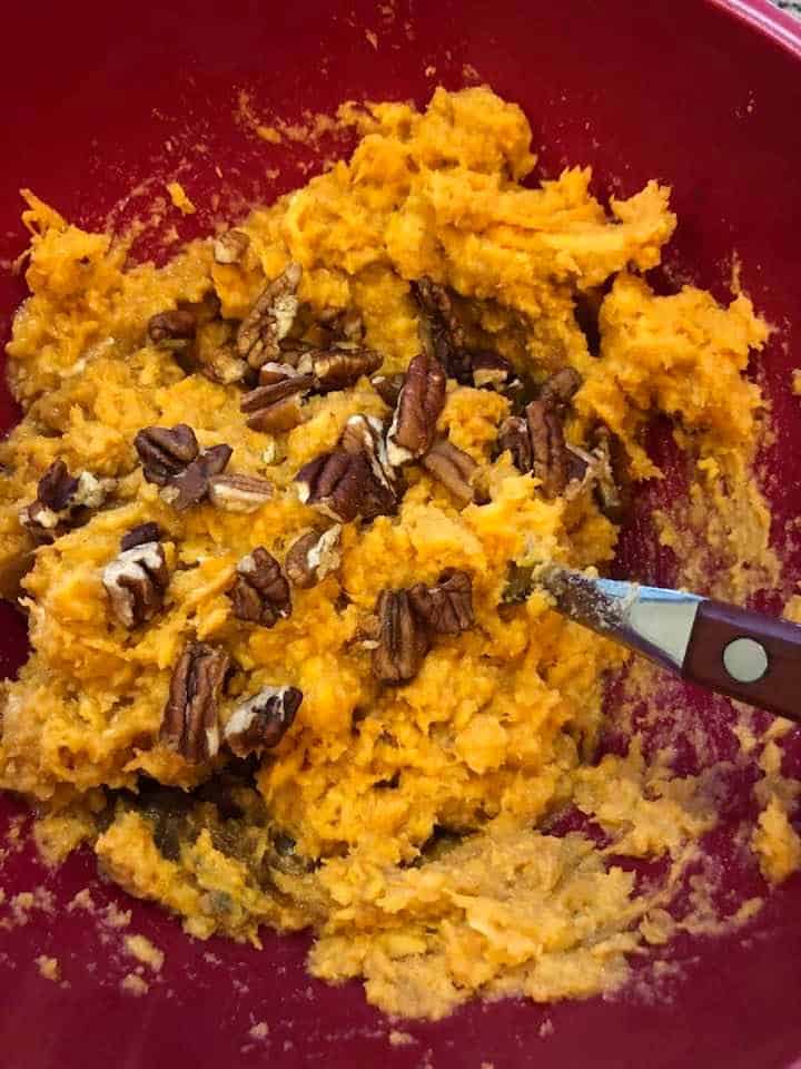 Sweet potato mixture with pecan pieces in a bowl. 