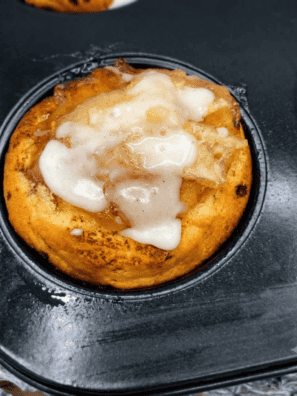 Air fryer apple pie cups drizzled with icing on a white plate