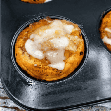 Air fryer apple pie cups drizzled with icing on a white plate