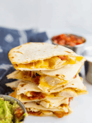Golden air fryer chicken quesadilla cut into wedges with melted cheese and grilled chicken inside.