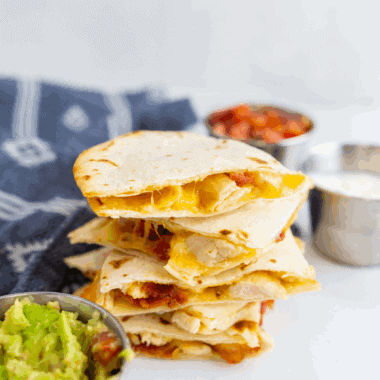 Golden air fryer chicken quesadilla cut into wedges with melted cheese and grilled chicken inside.